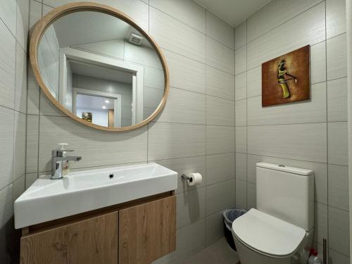 a bathroom with a sink and a mirror and a toilet at NO PARTY ALLOWED, Entire Brand New 3 bedroom townhouse, free unlimited fibre wifi and free parking in Wellington