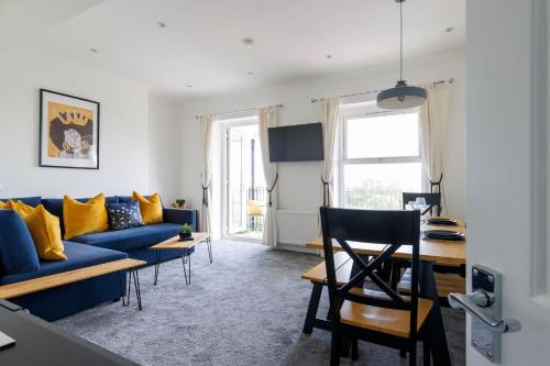 a living room with a blue couch and yellow pillows at Two bed Apartment with Sea Views in Bognor Regis in Bognor Regis