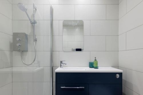 a white bathroom with a sink and a shower at Two bed Apartment with Sea Views in Bognor Regis in Bognor Regis