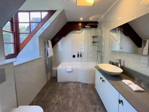 a bathroom with a sink and a toilet and a tub at Dunningwell Hall in Duddon