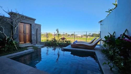 a swimming pool with a bench next to a house at Weda Villas in Ubud