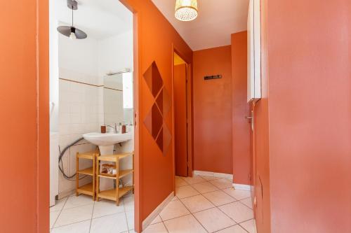 a bathroom with orange walls and a sink at Cozy and central apartment in Toulon