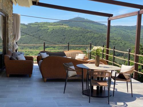 a patio with couches and a table and chairs at Bubo House in Črni Kal