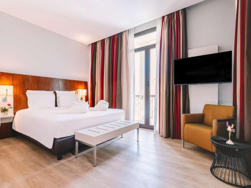 Pokój hotelowy z dużym łóżkiem i kanapą w obiekcie Mercure Roma Piazza Bologna w Rzymie