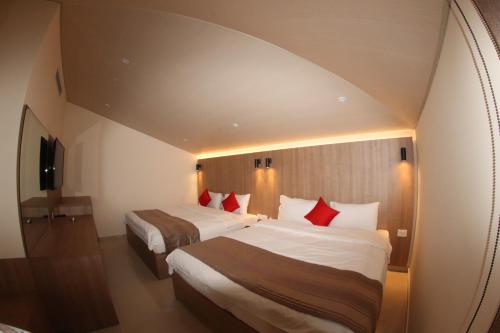 a hotel room with two beds with red pillows at Jounieh Suites Boutique Hotel in Jounieh