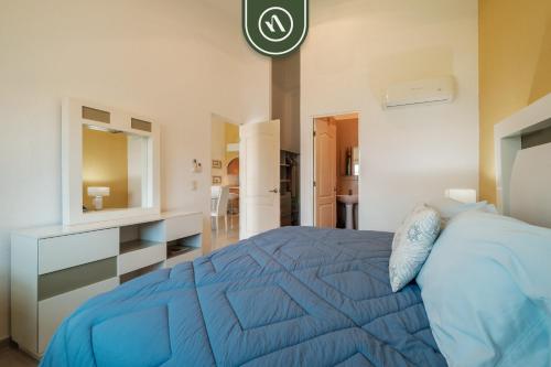 ein Schlafzimmer mit einem blauen Bett und einem Spiegel in der Unterkunft 2BR House - Private Patio - Acapulco in Acapulco
