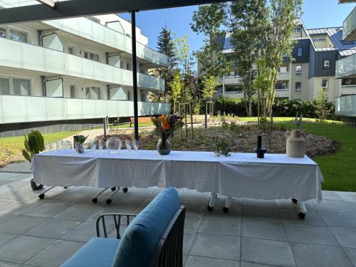 a long white table with a vase of flowers on it at DOMITYS Nancy in Nancy