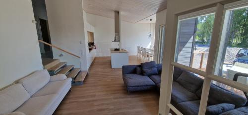 a living room with a couch and chairs and a staircase at Villa Koivunoksa in Kerava