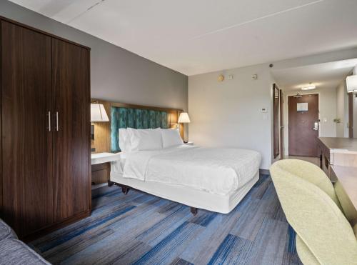 a hotel room with a bed and a desk and chairs at Hampton Inn Ridgefield Park in Ridgefield Park