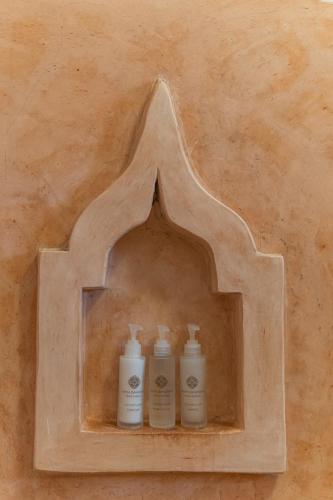 two bottles ofodorizers sitting on a shelf in a wall at Mr Kahawa in Paje