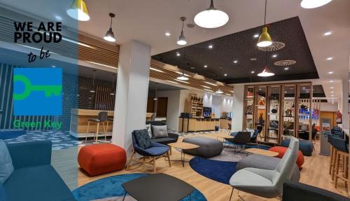 a store lobby with chairs and tables and a tv at Holiday Inn Express Bilbao Airport by IHG in Derio