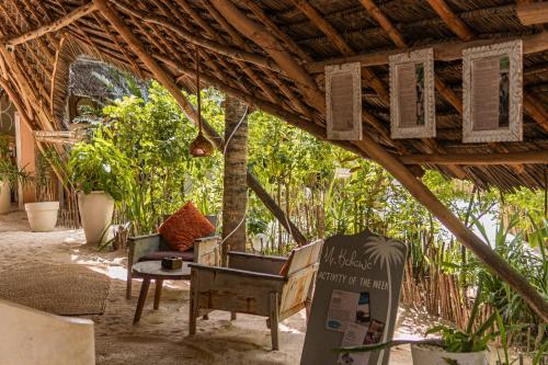an outdoor seating area with chairs and a table at Mr Kahawa in Paje