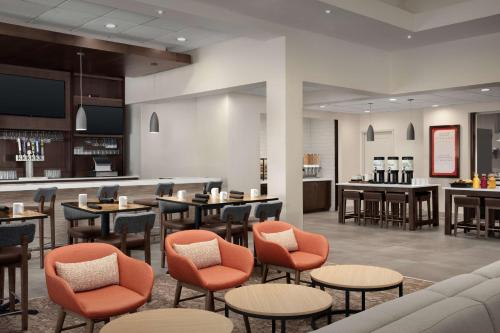 a restaurant with tables and chairs and a bar at Hilton Garden Inn Philadelphia-Fort Washington in Fort Washington