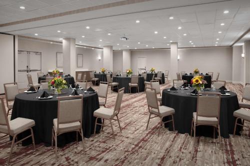 a conference room with tables and chairs with flowers on them at Hilton Garden Inn Philadelphia-Fort Washington in Fort Washington
