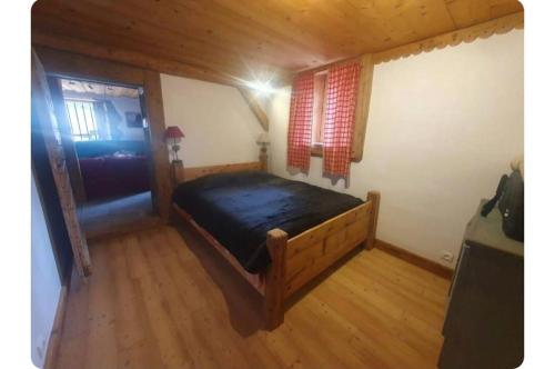 Cette chambre en bois comprend un grand lit. dans l'établissement Chalet Combe, à Samoëns
