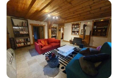 un salon avec un canapé rouge et une table dans l'établissement Chalet Combe, à Samoëns