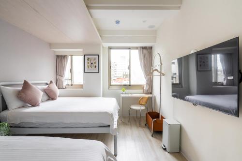a hotel room with two beds and a desk at 109台北旅館-台北109青旅 109 Taipei Hotel - Taipei 109 Hostel in Taipei