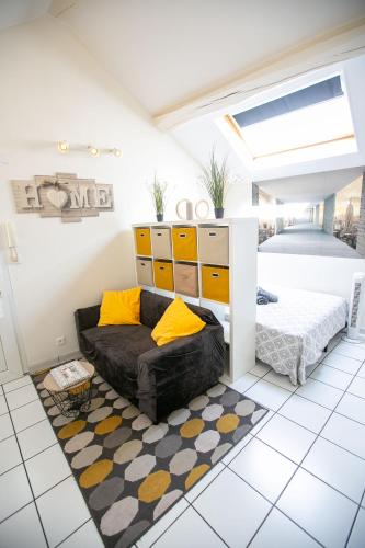 - un salon avec un canapé noir et des oreillers jaunes dans l'établissement L'Evasion - coeur de ville - WIFI - Gare, aux Mureaux