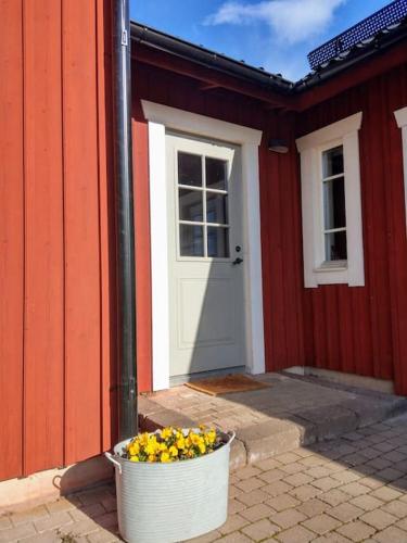 una maceta blanca de flores frente a un edificio rojo en Private apartment in Innertavle, en Umeå