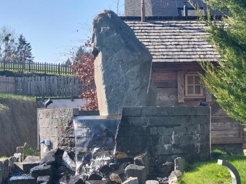 a water fountain in front of a house at Chalets Petry Spa & Relax in Bettel