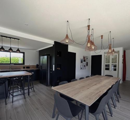 - une salle à manger et une cuisine avec une table et des chaises en bois dans l'établissement Villa Soizic, à La Terre du Pont