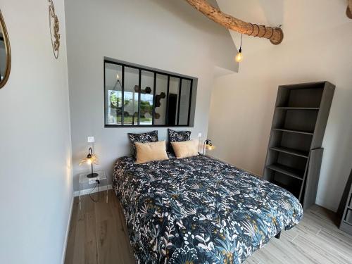 - une chambre avec un lit, une fenêtre et une étagère dans l'établissement Villa Soizic, à La Terre du Pont