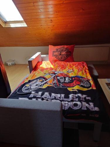 a bedroom with a bed with a motorcycle blanket at Apartmán Zukalka 2kk in Vítkovice