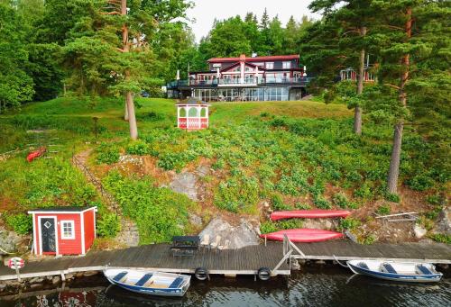 a house on a hill with boats on a dock at Hotel Ullinge in Eksjö