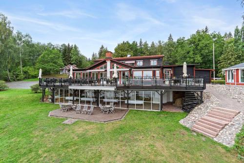 a large house with a large deck with chairs at Hotel Ullinge in Eksjö