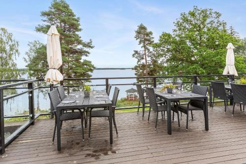 a table and chairs on a deck with a view of the water at Hotel Ullinge in Eksjö
