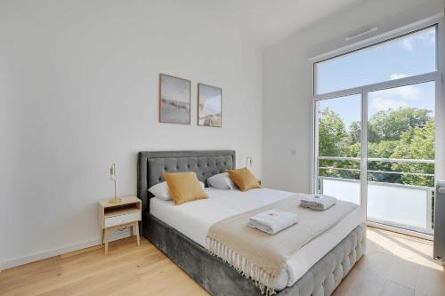 une chambre avec un lit et une grande fenêtre dans l'établissement Charming Apartment -2BR-6P- Nogent-sur-Marne, à Nogent-sur-Marne
