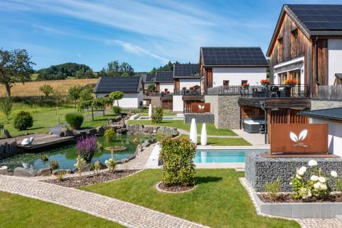 an image of a house with a garden and a swimming pool at Chalets Petry Spa & Relax in Bettel