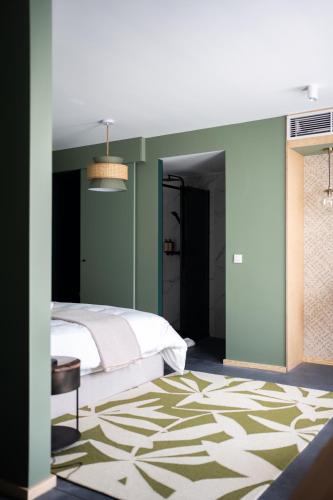 a bedroom with a bed and a green wall at L'Olivier in Mons
