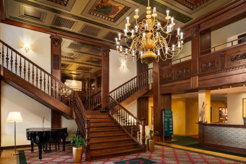 a large lobby with a staircase and a chandelier at Vienna House by Wyndham Thüringer Hof Eisenach in Eisenach