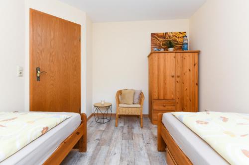 ein Schlafzimmer mit zwei Betten und einem Holzschrank in der Unterkunft Ferienwohnungen und Ferienhaus Polmann in Nordwerdum in Werdum