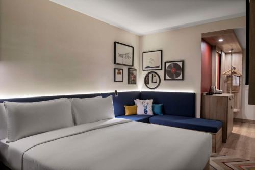 a bedroom with a large bed and a blue bench at Hampton By Hilton Istanbul Merter in Istanbul