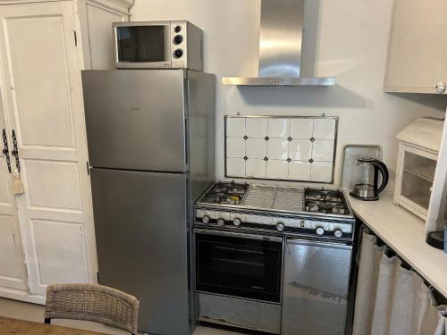 a kitchen with a stainless steel refrigerator and a microwave at Akasa on Lake Como in Menaggio