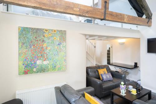 a living room with a couch and a painting on the wall at Sunday School House in Shrewsbury