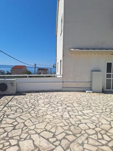 a white building with a stone floor next to a window at Apartments Villa Split Podstrana in Podstrana