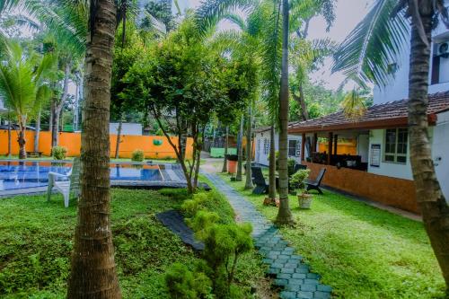 a resort with a swimming pool and palm trees at A One Calm Palace in Mirissa
