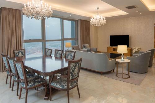 a dining room and living room with a table and chairs at Hilton Brazzaville Les Tours Jumelles Hotel & Residences in Brazzaville