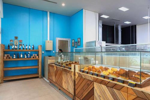 a bakery with blue walls and a display case with pastries at Wyndham Panbil Batam in Batam Center
