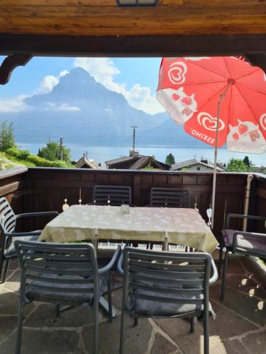 a table and chairs and an umbrella on a patio at Ferienhaus Beringer am Kallbach in Traunkirchen