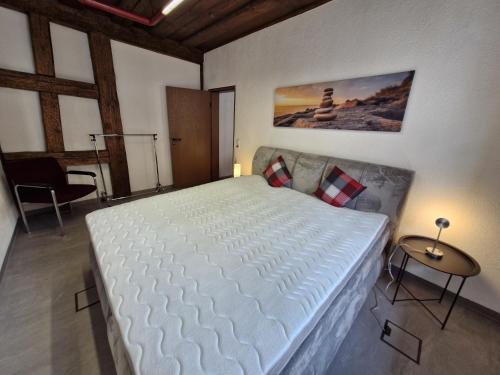 a bedroom with a large white bed and a table at Ferienwohnung Marktblick in Pottenstein