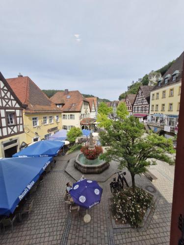 a town with umbrellas and tables and buildings at Ferienwohnung Marktblick in Pottenstein