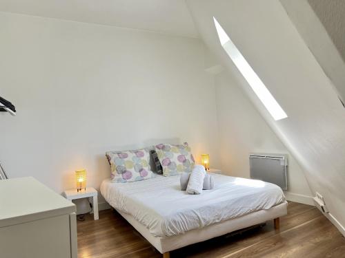 - une chambre blanche avec un lit et deux lampes dans l'établissement Charme Parisien - Sous les Toits de Paris à Opéra, à Paris