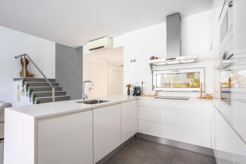 a kitchen with white cabinets and a sink at Stylish 3-Bedroom Villa Haven with a Private Pool in Albufeira