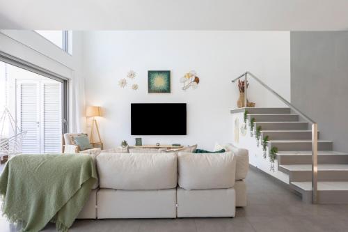 a living room with a couch and a tv at Stylish 3-Bedroom Villa Haven with a Private Pool in Albufeira