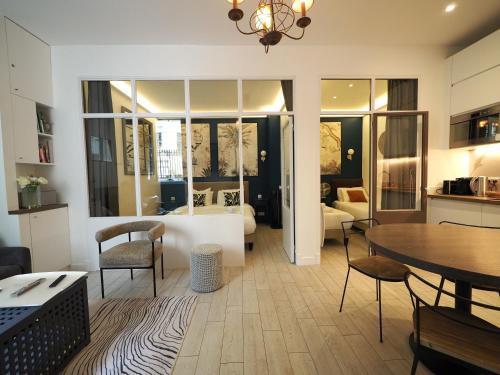 un salon avec une table et des chaises et une cuisine dans l'établissement Saint Germain Elegant ChicSuites, à Paris