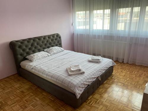 a bedroom with a bed with two towels on it at Niki Apartman in Kruševac